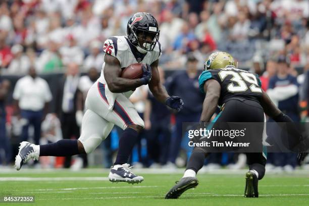 Lamar Miller of the Houston Texans runs the ball defended by Tashaun Gipson of the Jacksonville Jaguars in the fourth quarter at NRG Stadium on...