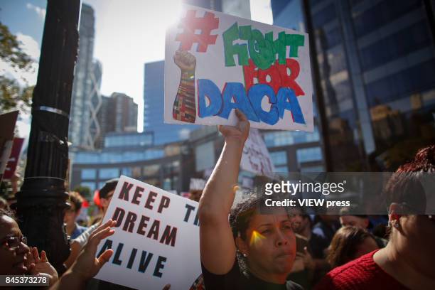 Woman holds a placard as she takes part during a march in protest of President Trump's decision on DACA in front of a Trump Hotel on September 9,...