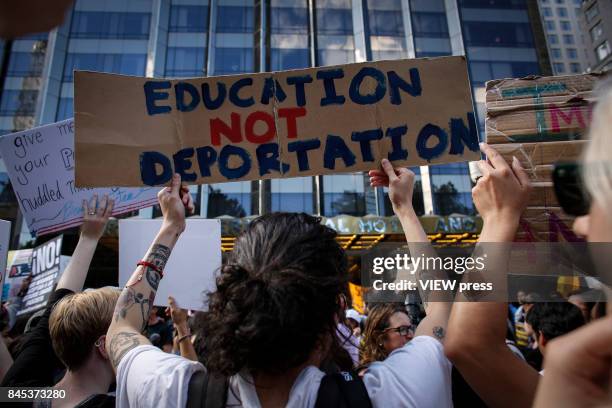 Woman holds a placard as she takes part during a march in protest of President Trump's decision on DACA in front of a Trump Hotel on September 9,...