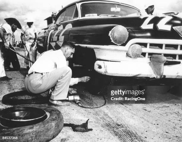 Car owner Raymond Parks affixes the lug nuts to his driver Red Byron's 1950 Cadillac. They went on to finish third in the inaugural Southern 500 that...