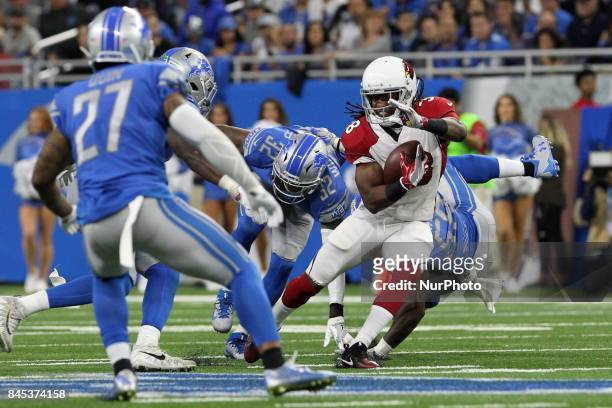 Arizona Cardinals running back Andre Ellington carries the ball up the field under the pressure of the Lions defense during the second half of an NFL...