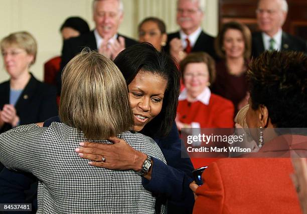 First lady Michelle Obama greets a guest while attending the "Lilly Ledbetter Fair Pay Act" bill signing in the East Room of the White House January...