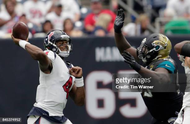 Deshaun Watson of the Houston Texans throws a pass under pressure by Abry Jones of the Jacksonville Jaguars in the fourth quarter at NRG Stadium on...