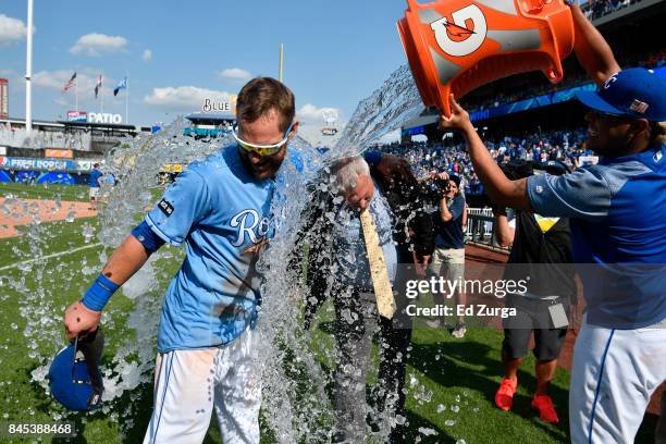 Alex Gordon of the Kansas City Royals and Fox Sports' Joel Goldberg are doused with water by Salvador Perez after a 11-3 win over the Minnesota Twins...