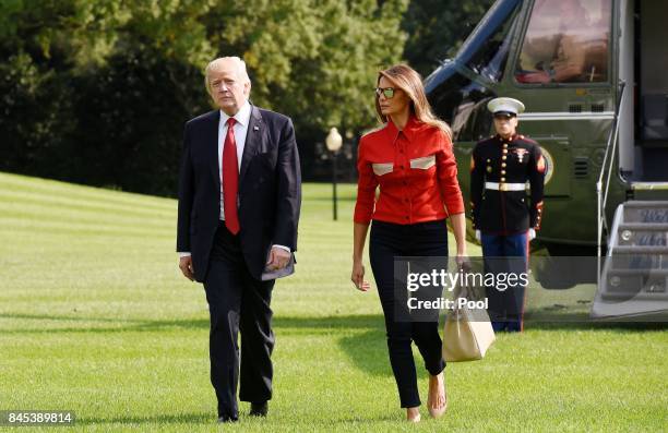 President Donald Trump and First Lady Melanie Trump walk from Marine One upon arrival on the South Lawn of the White House in Washington, DC,...