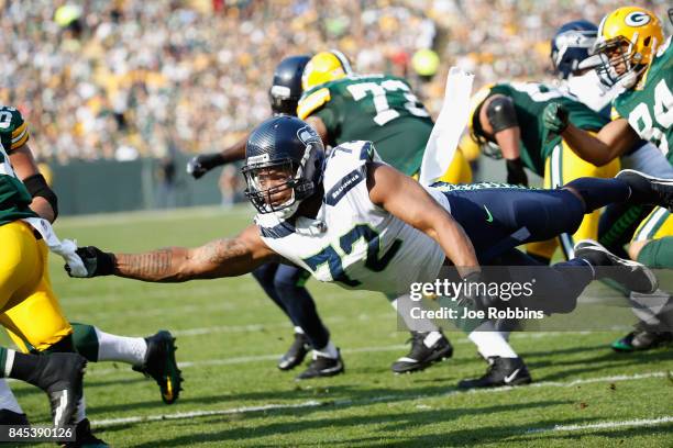 Michael Bennett of the Seattle Seahawks attempts to tackle Ty Montgomery of the Green Bay Packers during the first half at Lambeau Field on September...