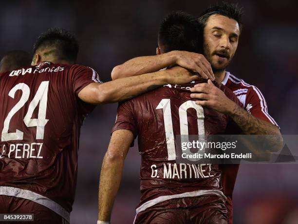 Gonzalo Martinez of River Plate celebrates with teammates Ignacio Scocco and Enzo Perez after scoring the second goal of his team during a match...