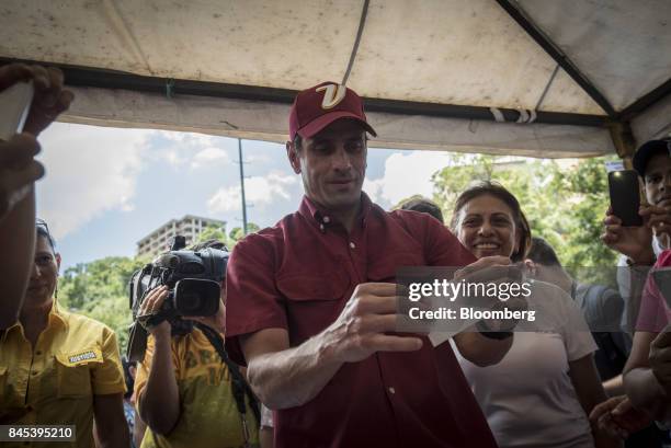 Henrique Capriles, opposition leader and governor of the State of Miranda, center, casts a ballot at a polling station during a primary election in...