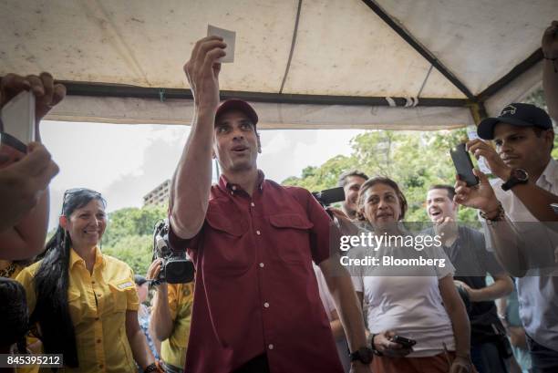 Henrique Capriles, opposition leader and governor of the State of Miranda, center, casts a ballot at a polling station during a primary election in...