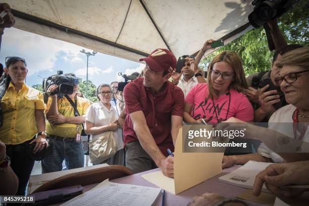 Henrique Capriles, opposition leader and governor of the State of Miranda, center, casts a ballot at a polling station during a primary election in...