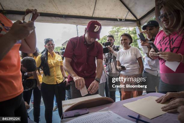 Henrique Capriles, opposition leader and governor of the State of Miranda, center, casts a ballot at a polling station during a primary election in...