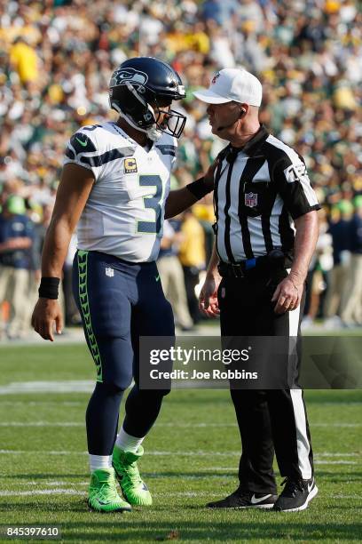 Russell Wilson of the Seattle Seahawks talks with referee John Parry during the first half of the game between the Seattle Seahawks and the Green Bay...