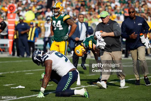 Sheldon Richardson of the Seattle Seahawks is helped by training staff during the first half against the Green Bay Packers at Lambeau Field on...