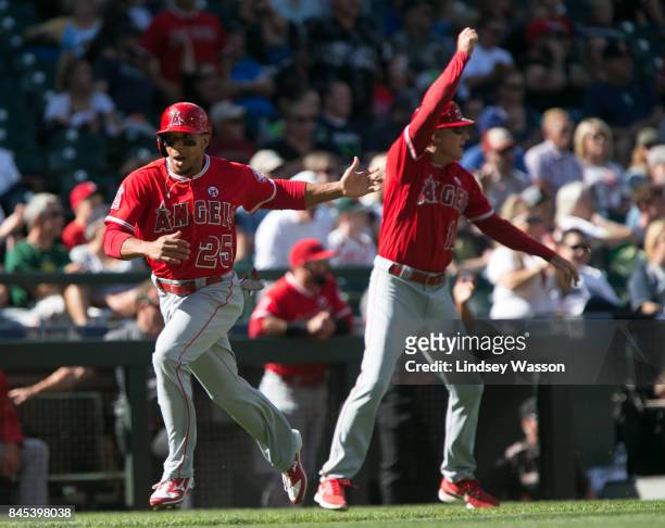 Ben Revere of the Los Angeles Angels of Anaheim waves on Mike Trout to score on a double by Justin Upton in the eighth inning against the Seattle...