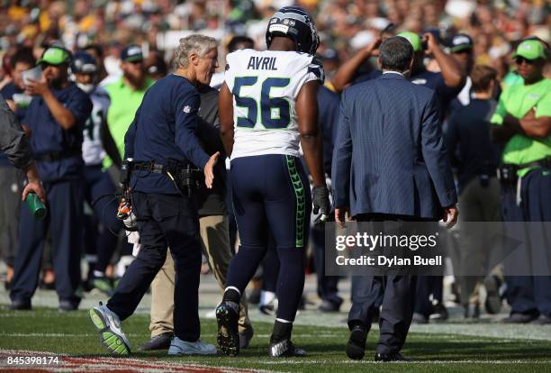 Cliff Avril of the Seattle Seahawks walks off the field after suffering an apparent injury during the first half against the Green Bay Packers at...