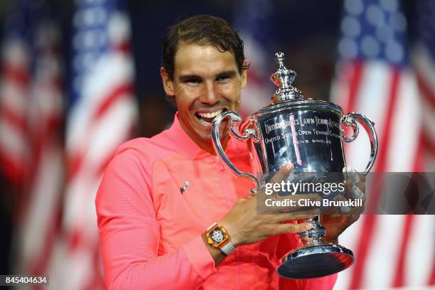 Rafael Nadal of Spain bites the championship trophy during the trophy ceremony after their Men's Singles Finals match on Day Fourteen of the 2017 US...