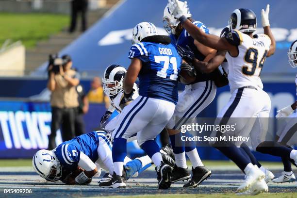 Jacoby Brissett of the Indianapolis Colts falls on the ball for a safety as Robert Quinn of the Los Angeles Rams reacts during the second half of a...