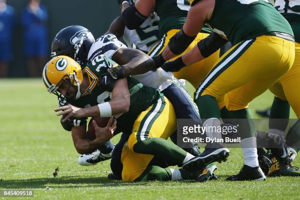 Cliff Avril of the Seattle Seahawks sacks Aaron Rodgers of the Green Bay Packers during the first quarter at Lambeau Field on September 10, 2017 in...