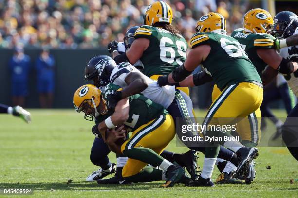 Cliff Avril of the Seattle Seahawks sacks Aaron Rodgers of the Green Bay Packers during the first quarter at Lambeau Field on September 10, 2017 in...