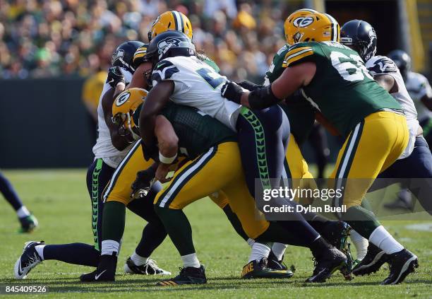 Cliff Avril of the Seattle Seahawks sacks Aaron Rodgers of the Green Bay Packers during the first quarter at Lambeau Field on September 10, 2017 in...