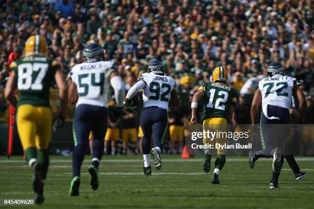 Nazair Jones of the Seattle Seahawks runs after intercepting a pass thrown by Aaron Rodgers of the Green Bay Packers during the first quarter at...