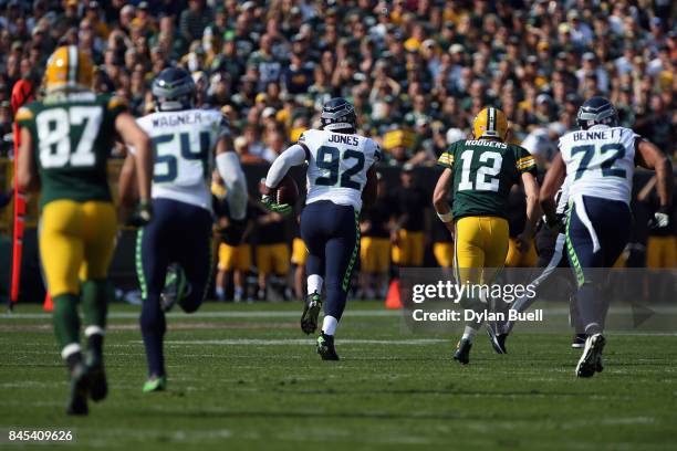 Nazair Jones of the Seattle Seahawks runs after intercepting a pass thrown by Aaron Rodgers of the Green Bay Packers during the first quarter at...