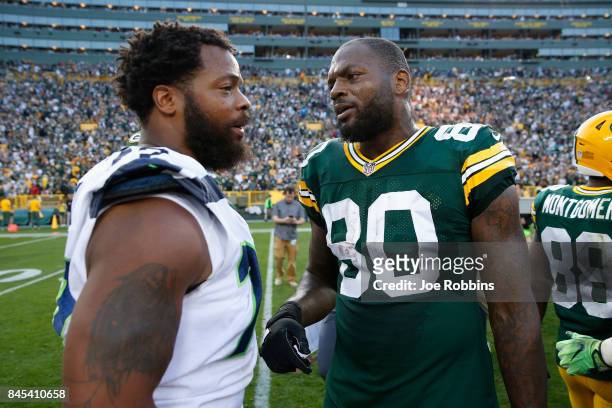Michael Bennett of the Seattle Seahawks talks with brother Martellus Bennett of the Green Bay Packers after the Packers defeated the Seahawks 17-9 at...