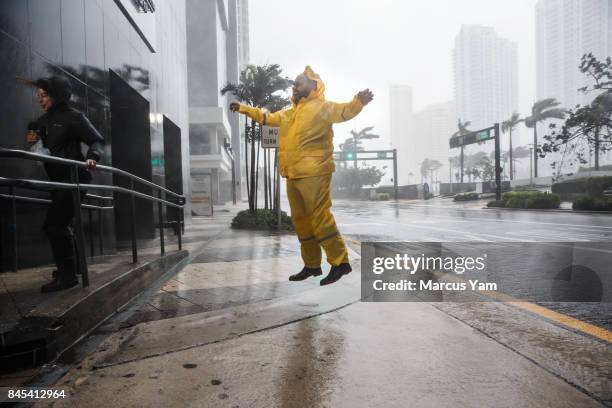 Weather reporters jump and cling on to illustrate the force of the winds caused by Hurricane Irma as it arrives in Miami, Fla., on Sept. 10, 2017.