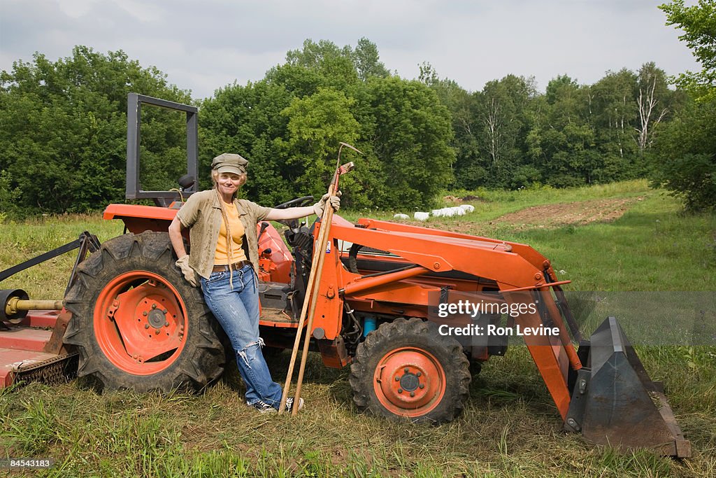  Worker standing by a tractor at an organic farm