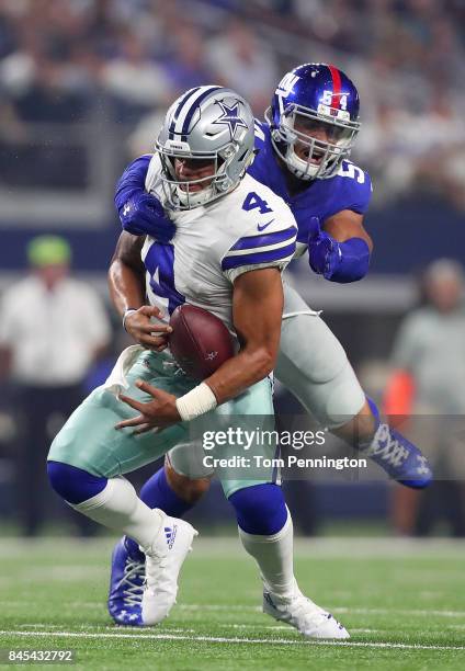 Dak Prescott of the Dallas Cowboys gets sacked by Olivier Vernon of the New York Giants in the second quarter of a game at AT&T Stadium on September...