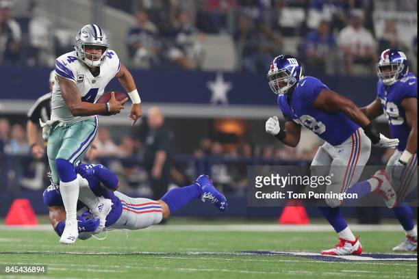 Dak Prescott of the Dallas Cowboys carries the ball against Olivier Vernon of the New York Giants in the second quarter at AT&T Stadium on September...