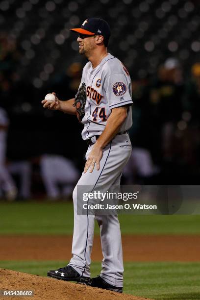 Luke Gregerson of the Houston Astros reacts after giving up a grand slam home run to Marcus Semien of the Oakland Athletics during the seventh inning...