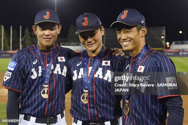 Hisanori Yasuda, Kotaro Kiyomiya and Kyota Fujiwara of Japan pose for a picture after beating Canada in the Bronze Medal Game following the WBSC U-18...