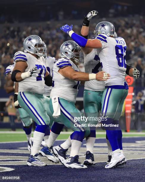 La'el Collins and Travis Frederick of the Dallas Cowboys rush to celebrate the touchdown by Jason Witten in the first half of a game against the New...