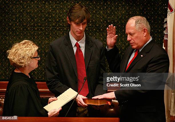 Illinois Lt. Governor Pat Quinn is sworn in as Governor by Justice Anne Burke as his son Patrick holds the bible following Governor Rod Blagojevich's...