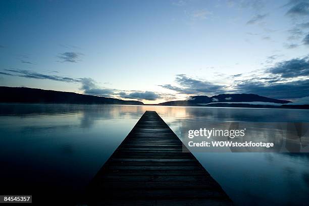 jetty on lake tarawera at sunrise - rotorua stockfoto's en -beelden