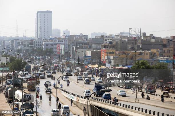 Traffic travels along a highway as a newly constructed apartment building stands in the background in Karachi, Pakistan, on Tuesday, Aug. 22, 2017....