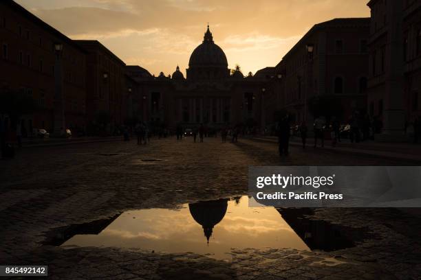 Sunset reflections after thunderstorm with the dome of the Basilica of St. Peter at Via della Conciliazione in Rome.