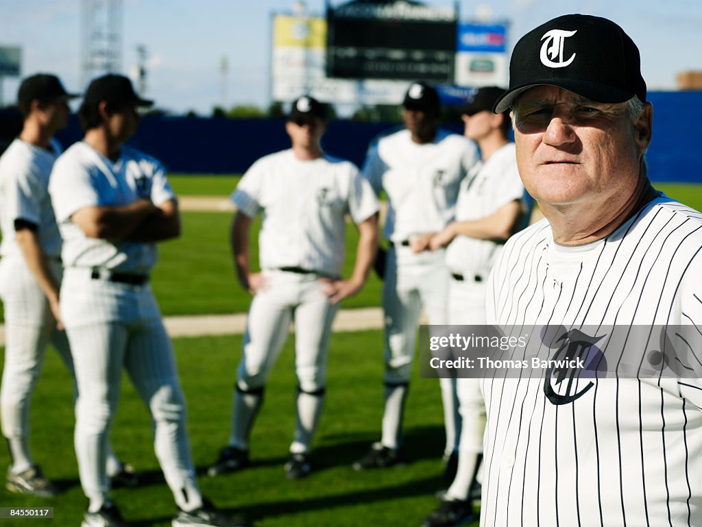 Baseball coach standing in front of players