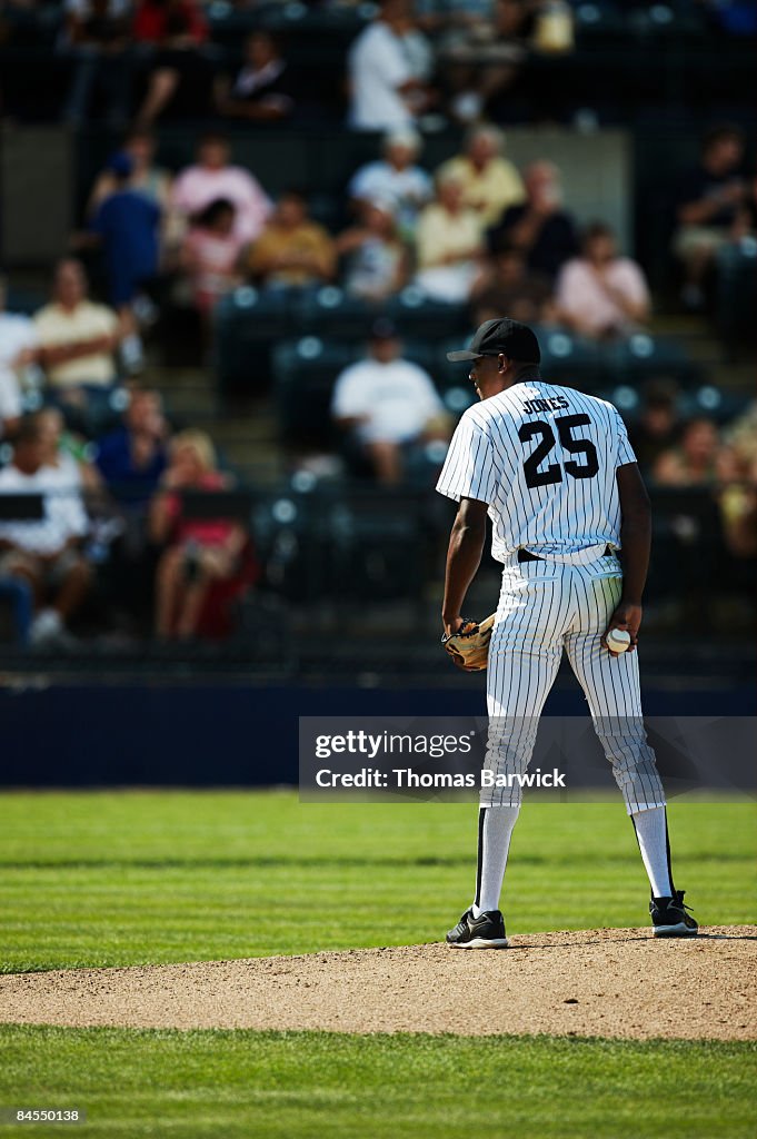 Pitcher standing on mound preparing to pitch