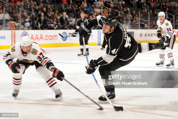 Raitis Ivanans of the Los Angeles Kings shoots the puck while being defended by Adam Burish of the Chicago Blackhawks on January 29, 2009 at Staples...