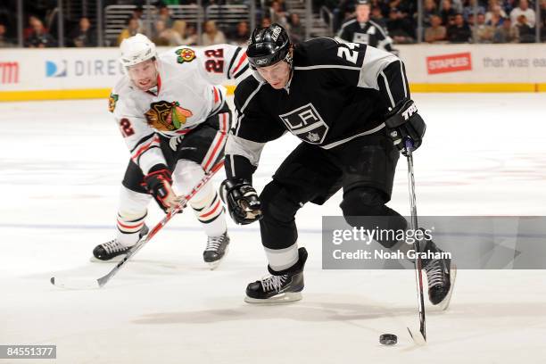 Alexander Frolov of the Los Angeles Kings handles the puck while being pursued by Troy Brouwer of the Chicago Blackhawks on January 29, 2009 at...