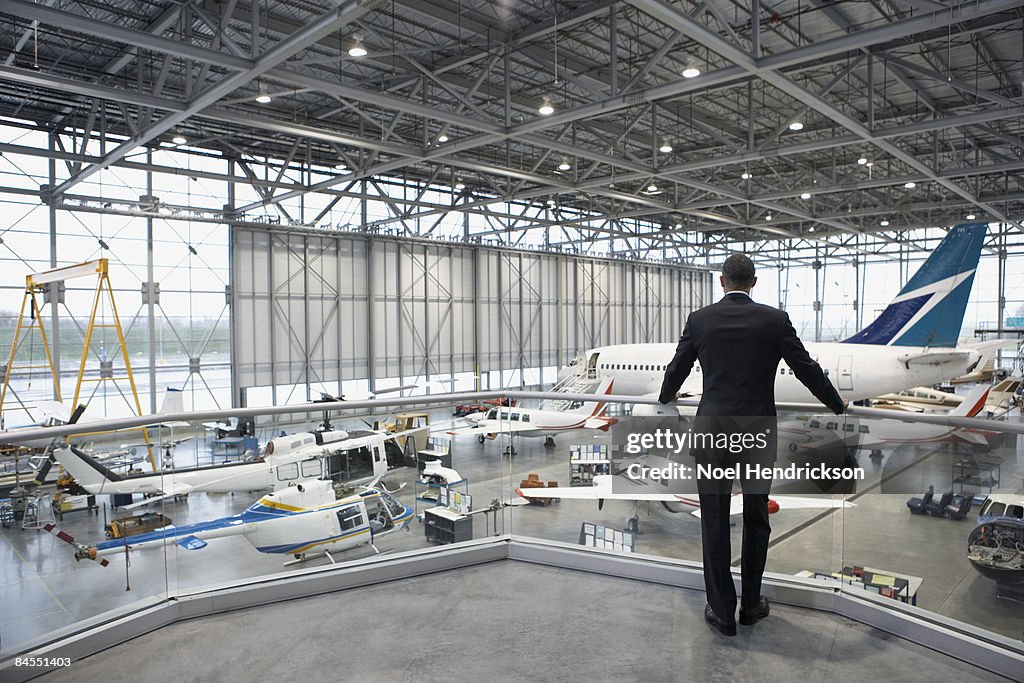 Businessman overlooking hangar of aircrafts 
