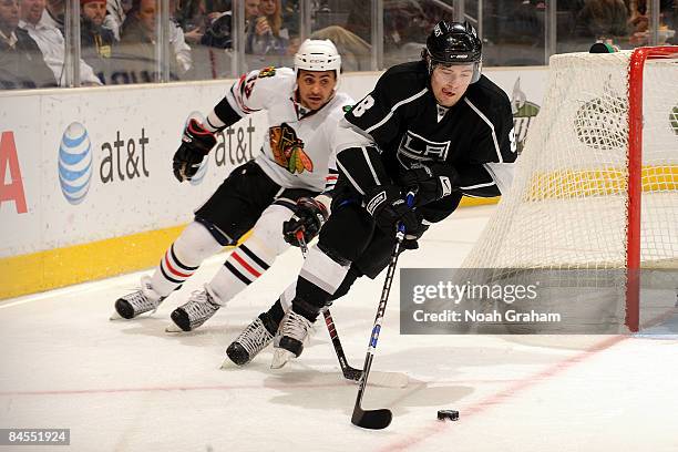 Drew Doughty of the Los Angeles Kings handles the puck as Dustin Byfuglien of the Chicago Blackhawks gives pursuit on January 29, 2009 at Staples...