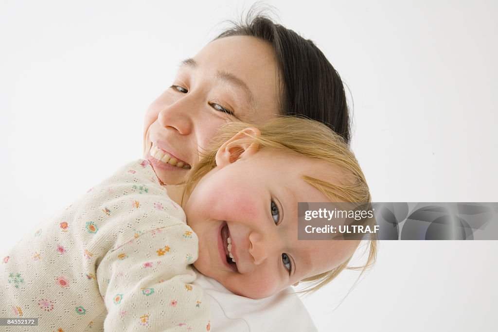 Mother is holding her daughter. 