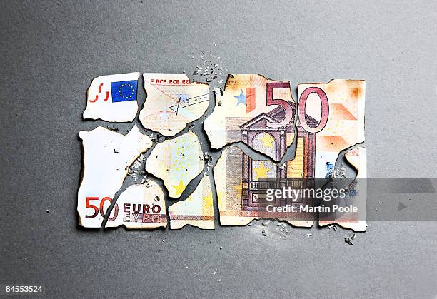 burnt 50 euro being put back togather - all european currencies stock pictures, royalty-free photos & images