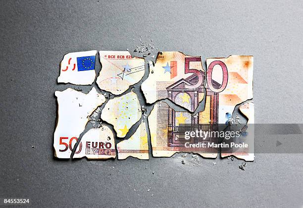 burnt 50 euro being put back togather - 2009 recession stock pictures, royalty-free photos & images