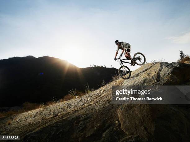 mountain biker descending on slick rock trail - mountain bike foto e immagini stock