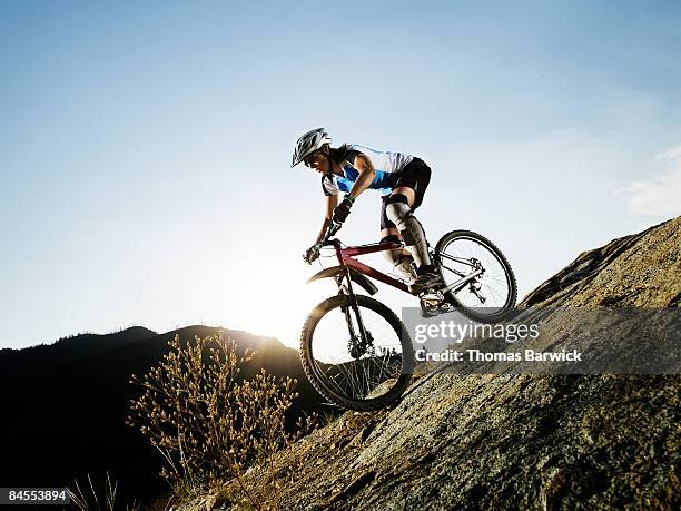 female mountain biker descending on trail - mountain bike foto e immagini stock