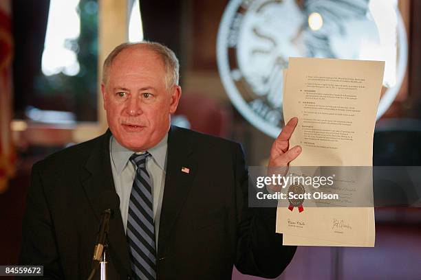 Illinois Governor Pat Quinn holds up an executive order he signed forming a reform commission to try and clean up Illinois politics during his first...